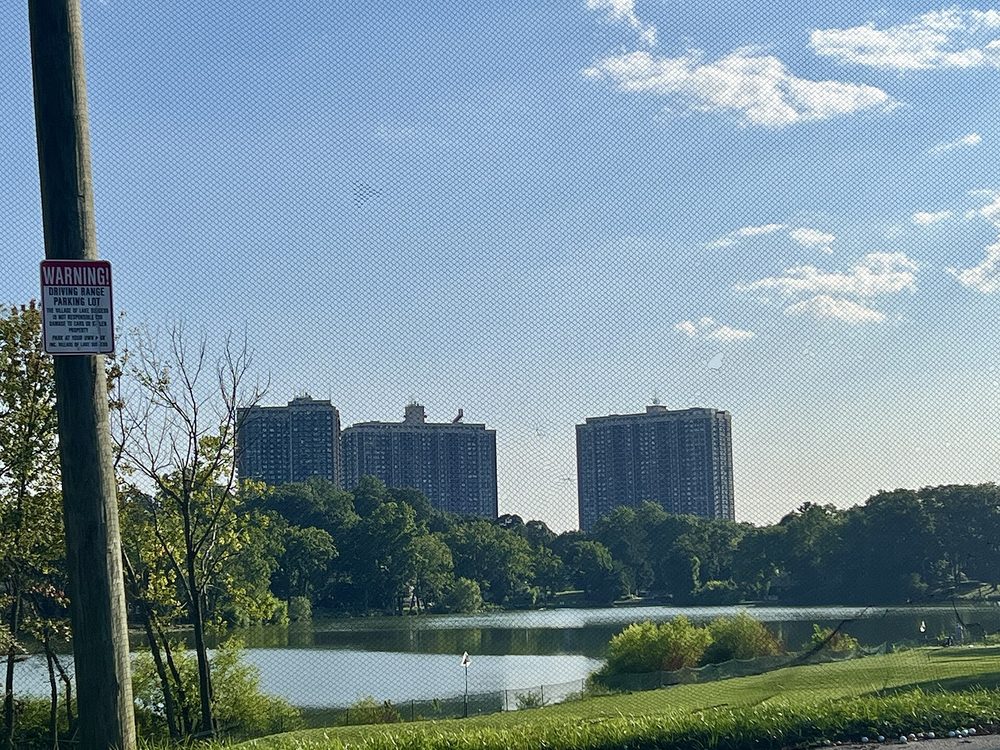 Edificios residenciales frente a un lago junto a un club de golf